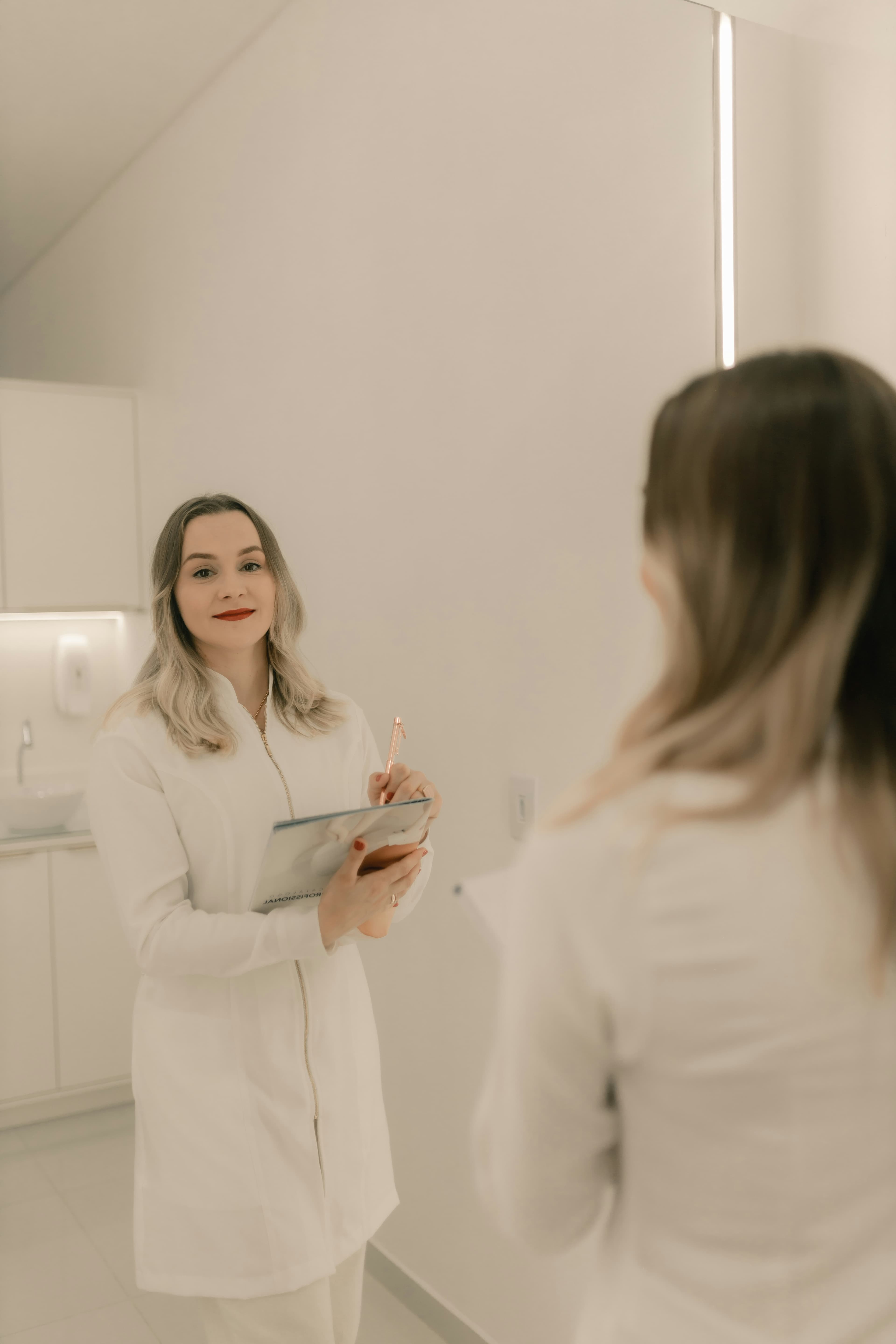 Profissional de estética atendendo uma cliente na cadeira